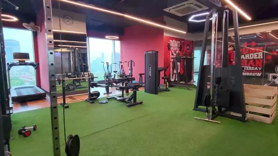 A WTF functional training zone on green turf with a cable machine and treadmills by the windows