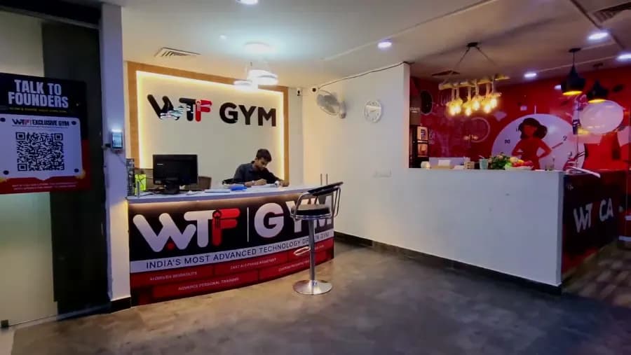 A WTF gym reception desk with the WTF Gym sign lit behind it