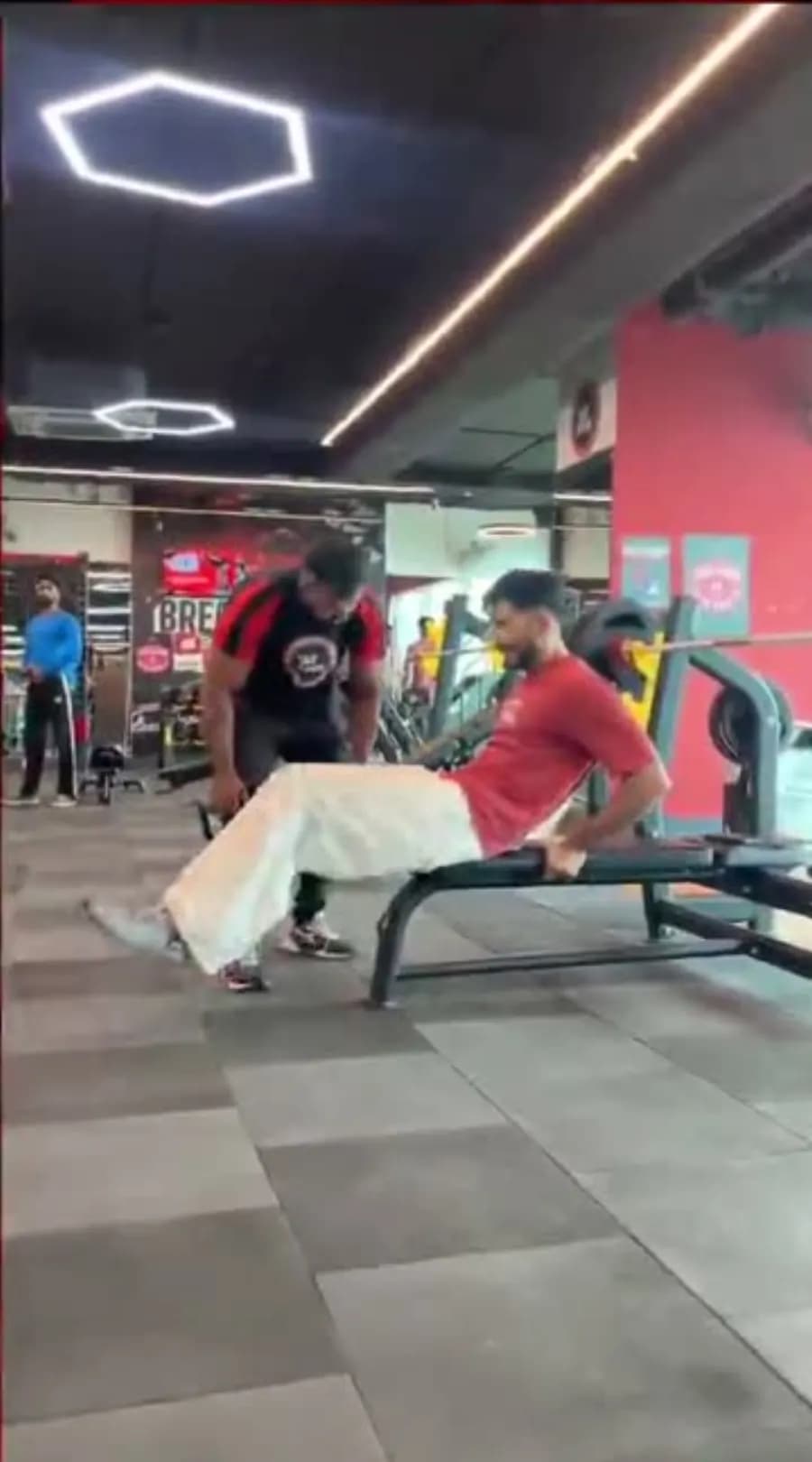 A WTF trainer coaching a member through a bench exercise